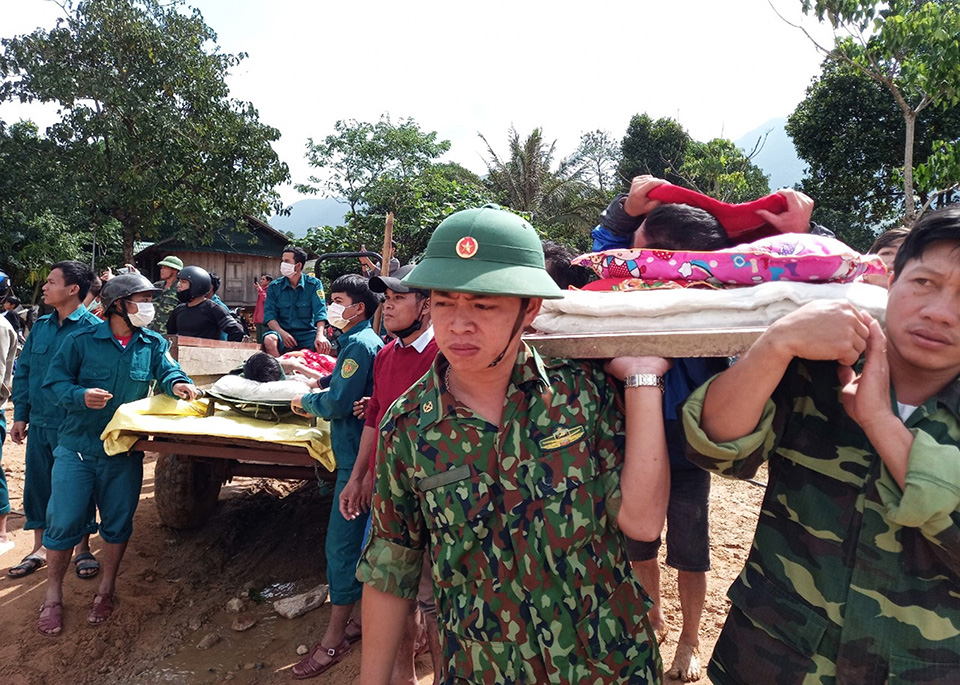 Cán bộ và người dân đưa hai anh Lê Văn Dùy và Hồ Văn Sinh đi cấp cứu sau khi bị núi sạt lở làm bị thương nặng.